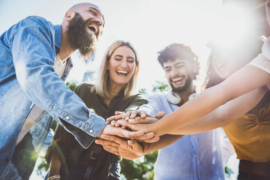 Multiracial-happy-young-people-stacking-hands-on-top-of-each-other---Diverse-friends-unity-togetherness-in-volunteer-community---Concept-about-college,-relati