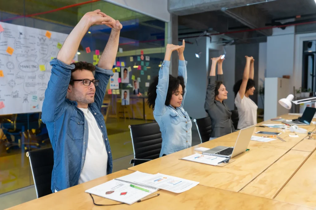 Workers-doing-stretching-exercises-in-a-business-meeting-at-the-office-1332693985_7952x5304